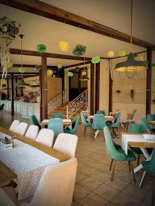 a restaurant with green chairs and tables and tables and tablesktop at Tryavna Lake Hotel & SPA in Tryavna