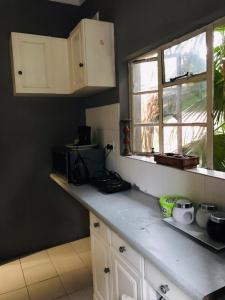 a kitchen with white cabinets and a counter top at Corfield in Durban