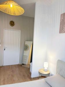 a living room with a bed and a yellow light at Studio Prestige, Cocon de Charme & Confort in Saint-Quentin