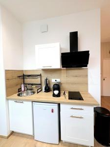 a kitchen with white cabinets and a counter top at Studio Prestige, Cocon de Charme & Confort in Saint-Quentin +5 photos