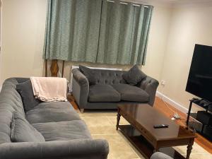 a living room with a couch and a table at Standish Haven Ensuite Room in Standish