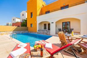 a villa with a swimming pool and a table and chairs at Odysseus Villa in Plaka