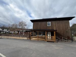 ein großes Holzgebäude mit Veranda und Zaun in der Unterkunft Vreta Hotel in Vretarna