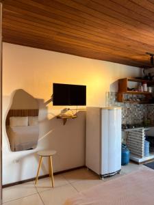 a room with a bed and a television on a wall at Pituba Vile - Apartamento Mandala in Itacaré
