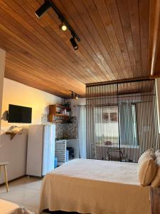 a bedroom with a large bed with a wooden ceiling at Pituba Vile - Apartamento Mandala in Itacaré