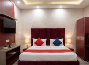 a bedroom with a large bed with colorful pillows at Hotel Cloud Inn in New Delhi +8 photos