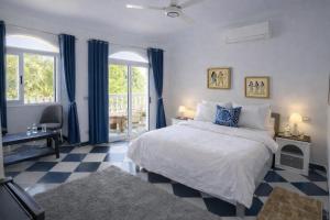 a bedroom with a bed with blue curtains and a checkered floor at Ali Baba Hotel in Luxor