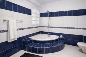 a blue and white bathroom with a tub and a toilet at Ali Baba Hotel in Luxor +31 photos