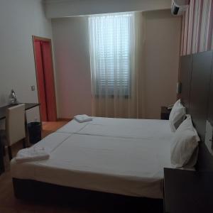 a bedroom with a large white bed with a window at Hotel Lagar do Lago in Castanheira de Pêra +1 photo