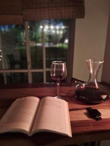an open book and a glass of wine on a wooden table at Anam Cara in Isla del Rincón +24 photos
