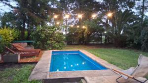 a swimming pool in a yard with chairs and lights at Anam Cara in Isla del Rincón