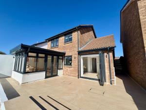 a brick house with large windows and a patio at Santíago Retreat in Wenvoe