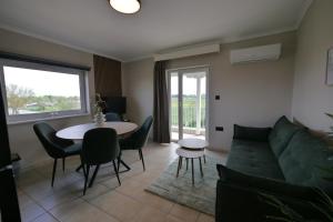 a living room with a couch and a table at Aithra Suite - Europa Hotel in Korinos