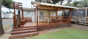 a wooden deck with a pergola on a house at Location mobil-home camping Pedro Confort & détente in Le Grau-dʼAgde