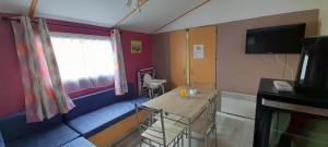 a living room with a table and a tv at Location mobil-home camping Pedro Confort & détente in Le Grau-dʼAgde