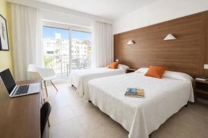 a hotel room with two beds and a laptop on a desk at Prince Park in Benidorm +63 photos