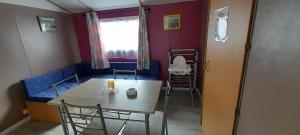 a small room with a table and a blue couch at Location mobil-home camping Pedro Confort & détente in Le Grau-dʼAgde