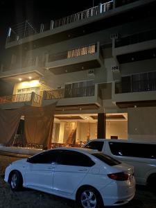 a white car parked in front of a building at Seawave Beach and Dive Resort in Lobo