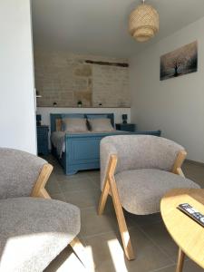 a bedroom with a bed and two chairs and a table at Ô Ptit Verger in Coulon