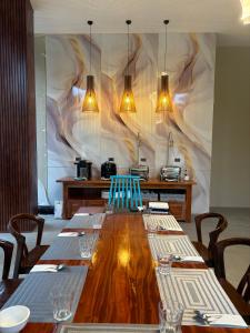 a dining room with a long wooden table with chairs at Seawave Beach and Dive Resort in Lobo