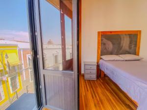 a bedroom with a bed and a large window at Spacious modern and centrally located in Puebla