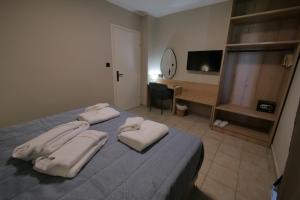 a bedroom with a bed with two towels on it at Aithra Suite - Europa Hotel in Korinos +16 photos