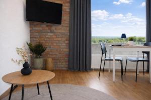 a living room with a table and a tv at Exklusive Studio-Apartments mit Balkon in Bad Rothenfelde