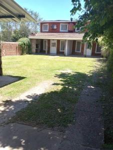 a large house with a grass yard with a building at El Rancho del Tucu in Colón