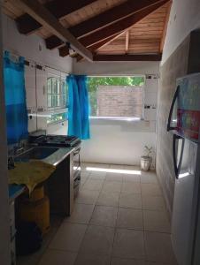 a kitchen with a sink and a refrigerator and a window at El Rancho del Tucu in Colón