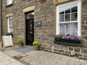 a brick building with two windows and flowers on the door at Evangelisa in Lampeter