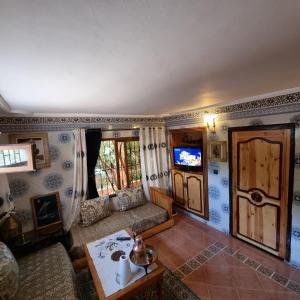 a living room with a couch and a tv at Momo's villa in Aït Ourir