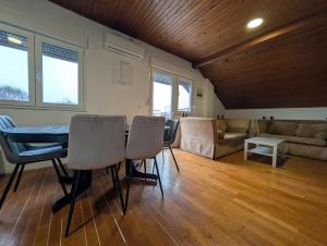 a living room with a table and chairs and a couch at Spacious Condo w Terrace & Piano in Sesvete +49 photos