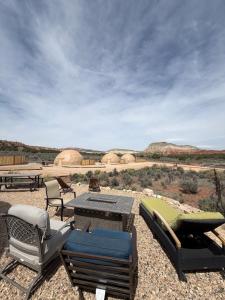 a patio with chairs and a table in the desert at Bryce Glamp And Camp in Cannonville