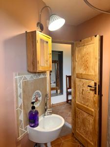 a bathroom with a sink and a wooden door at Garys Old Farmhouse in Kamária +25 photos