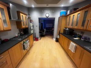 a kitchen with wooden cabinets and a wooden floor at Wimbledon fortnight in London