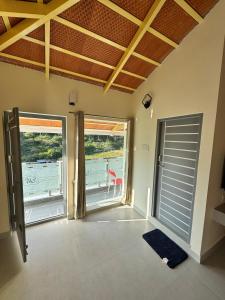 a room with a door and two large windows at Drizzle Home - A Cosy Stay in Yercaud