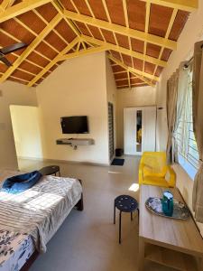a room with a bed and a table and a tv at Drizzle Home - A Cosy Stay in Yercaud