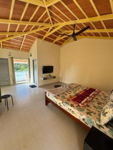 a bedroom with a bed and a flat screen tv at Drizzle Home - A Cosy Stay in Yercaud