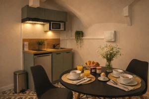 a kitchen with a table with cups and saucers at le gîte du soleil in Lézat-sur-Lèze