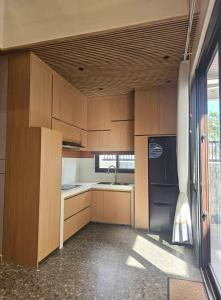 a kitchen with wooden cabinets and a sink at Villa Cassandra Atasha Private Resort - Celestine in Cuayan