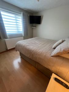 a bedroom with a large bed and a television at Cozy Room at Willow House in Leyland