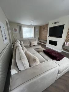 a living room with a white couch and a tv at Cozy Room at Willow House in Leyland