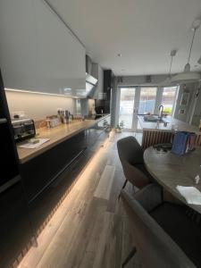 a large kitchen with wooden floors and a table in it at Cozy Room at Willow House in Leyland