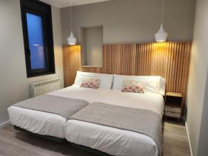 a bedroom with a large white bed with two pillows at CREDENCIAL Bulevar in Sarria