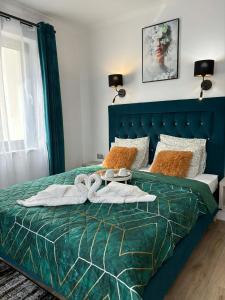 a bedroom with a green bed with towels on it at VILLA SOLARIS Ustka - PENSJONAT Z 2026R,ROWERY GRATIS, WYPOCZYNEK tylko DLA DOROSŁYCH ! in Ustka