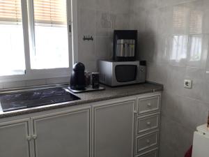 a kitchen with a microwave and a counter top at Isabella Chipiona in Chipiona +13 photos