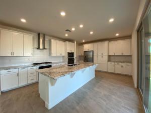 a large kitchen with white cabinets and a large island at Cozy Private master bedroom in a single family house in Elk Grove