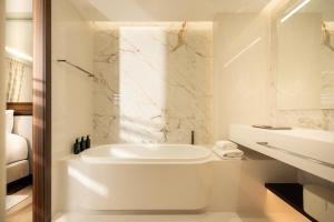 a white bathroom with a tub and a sink at Maison Bauchart in Paris +61 photos