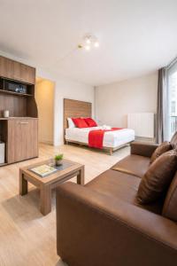 a living room with a bed and a couch at Hotel Le Faidherbe -Plages -Nausicaa -Q-Park in Boulogne-sur-Mer +46 photos
