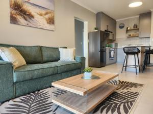 a living room with a green couch and a table at Beach Haus Unit 1 in Cape Town